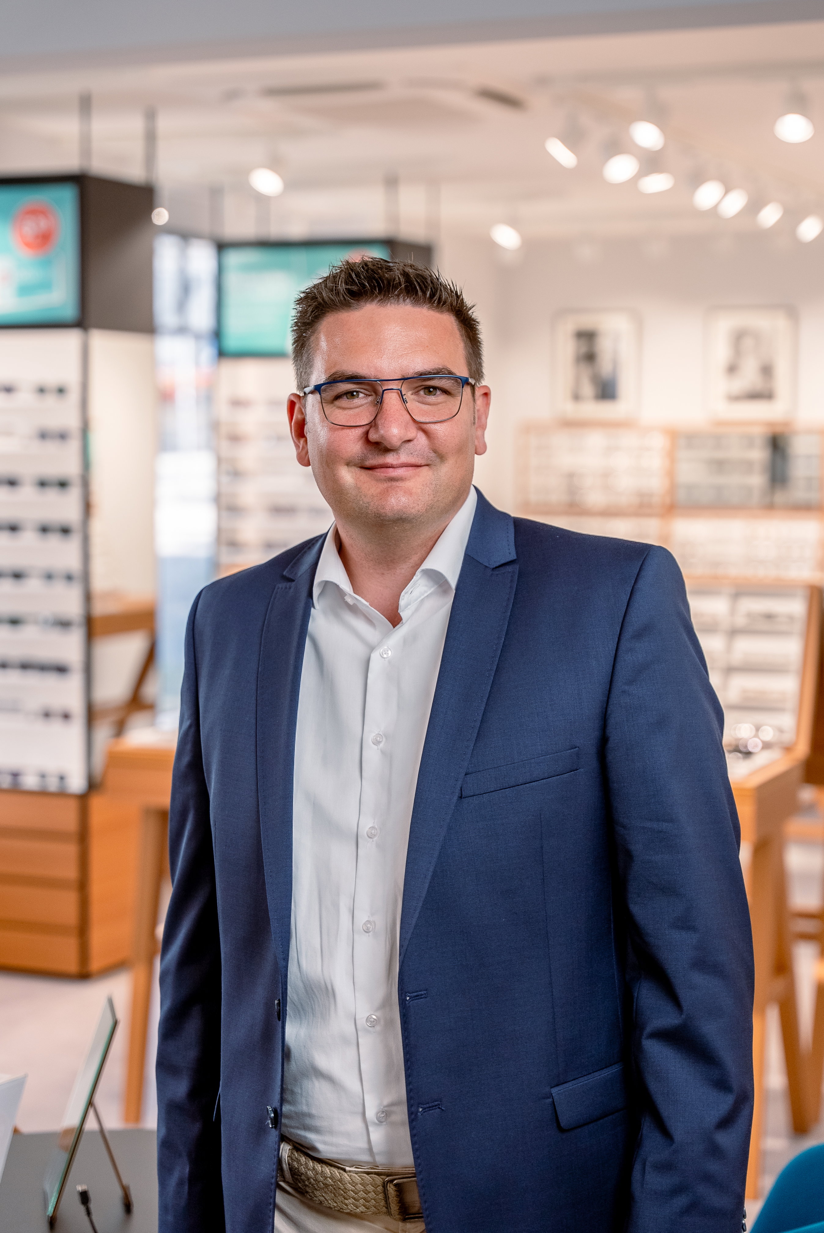 Das Bild zeigt einen Mitarbeiter mit Brille und blauem Sakko.