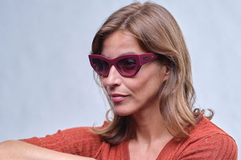 zu sehen ist eine Frau mit einer Sonnenbrille in leuchtendem Brombeer-Rot