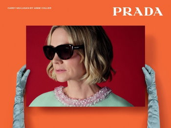 Das Bild zeigt eine Frau mit Sonnenbrille und einem Prada Logo vor einem orangenen Hintergrund.