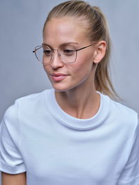 Zu sehen ist eine Frau mit einer Runden Metall-Brille