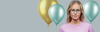 Zu sehen ist eine Frau mit einer Brille von Abele Optik und im Hintergrund ein goldener und zwei hellgrüne Ballons.