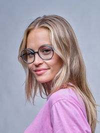 Zu sehen ist eine Frau mit einer runden Brille