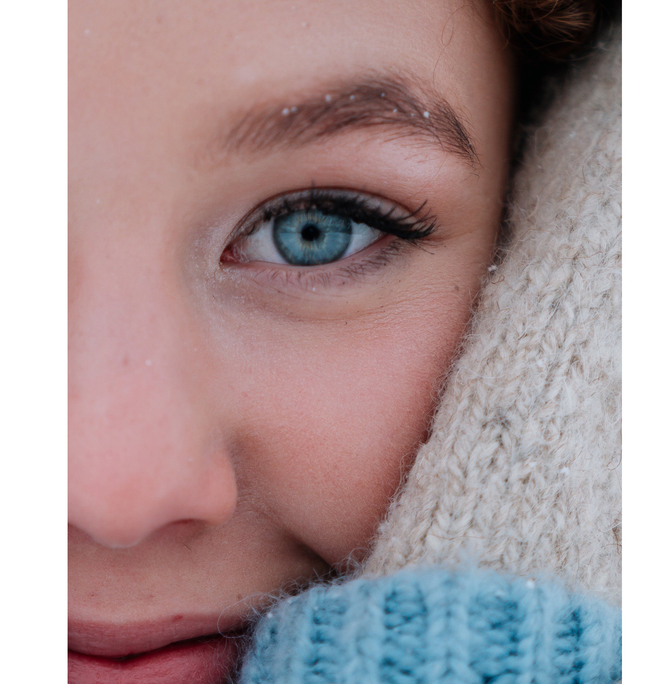 Das Bild zeigt eine Person in Nahaufnahme mit strahlend blauen Augen.