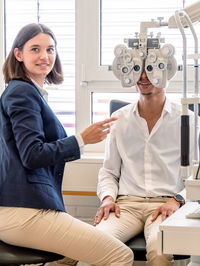 Zu sehen ist eine Optikerin bei einem Sehtest