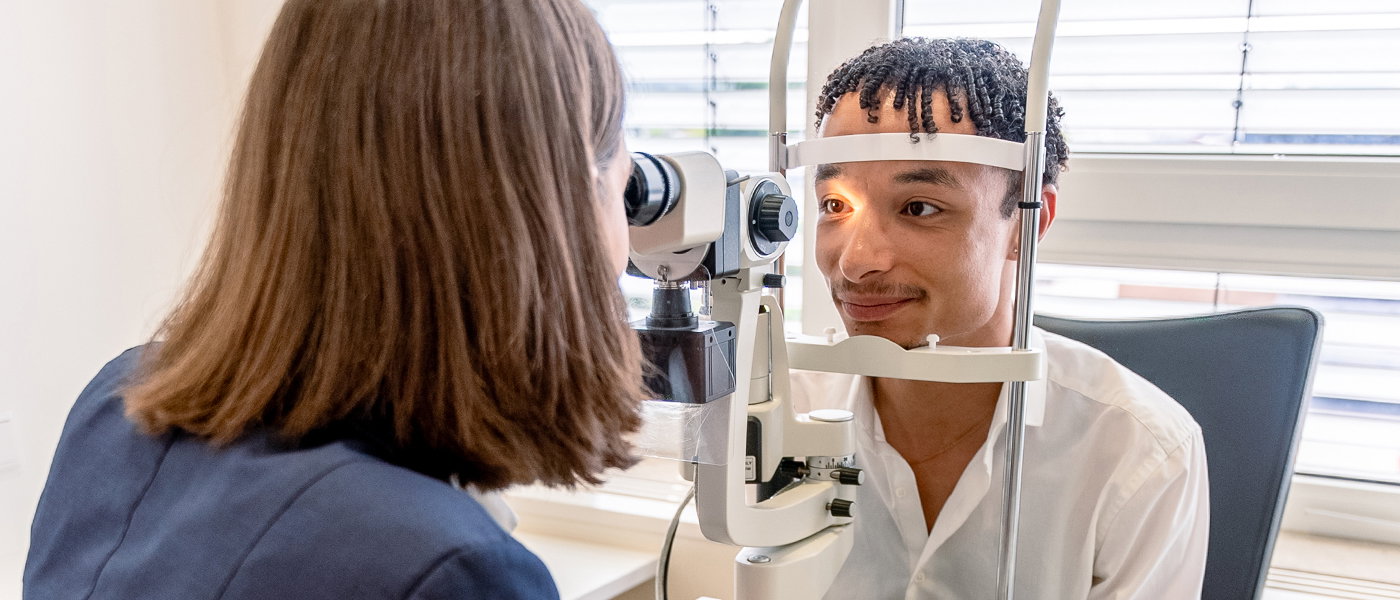 Zu sehen ist eine Optikerin von Abele Optik mit einem Kunden beim Sehtest.