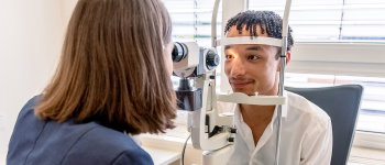 Zu sehen ist eine Optikerin von Abele Optik mit einem Kunden beim Sehtest.