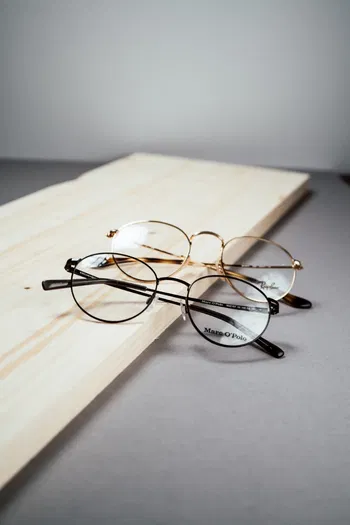 Zu sehen sind zwei runde Brillen auf einem Holzscheit.