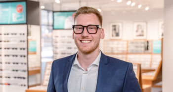 Das Bild zeigt einen Mitarbeiter in einer Filiale in Nahaufnahme.
