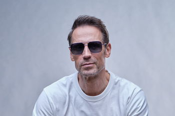 zu sehen ist ein Mann mit eleganter Metall-Sonnenbrille